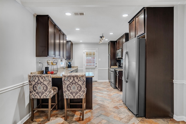 4951 Lynbar Ave, Memphis, TN 38117 - kitchen with stainless steel appliances, dark brown cabinets, light stone counters, baseboards, and recessed lighting