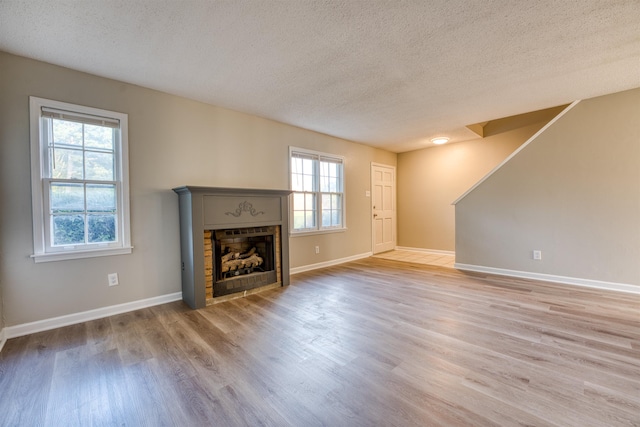 5432 Burton Church Cv Unit 5432, Bartlett, TN 38134 - unfurnished living room featuring a textured ceiling, wood finished floors, a fireplace, and baseboards