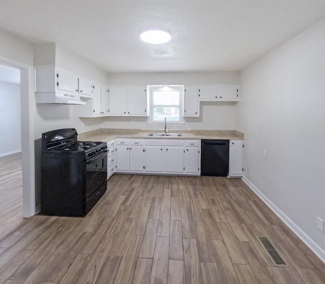 3547 Randolph St, Memphis, TN 38127 - kitchen with black appliances, a sink, light wood-style floors, white cabinets, and under cabinet range hood