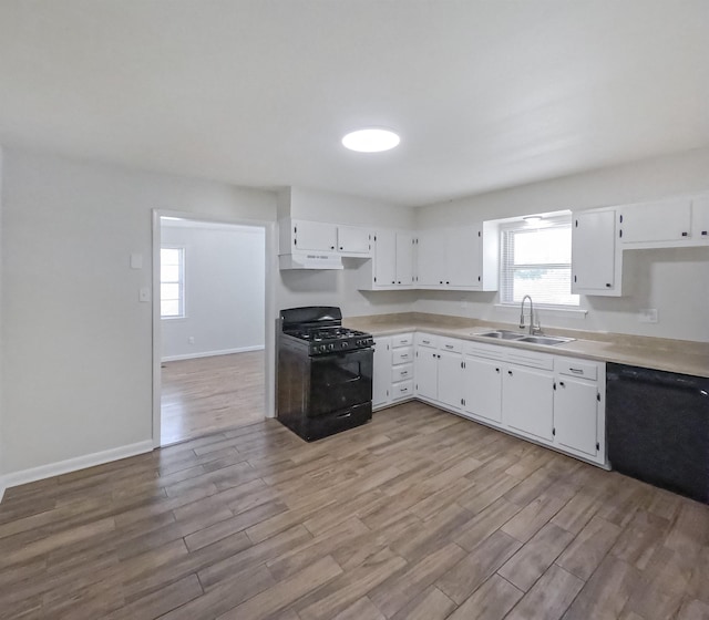 3547 Randolph St, Memphis, TN 38127 - kitchen with black appliances, a sink, wood finished floors, and light countertops