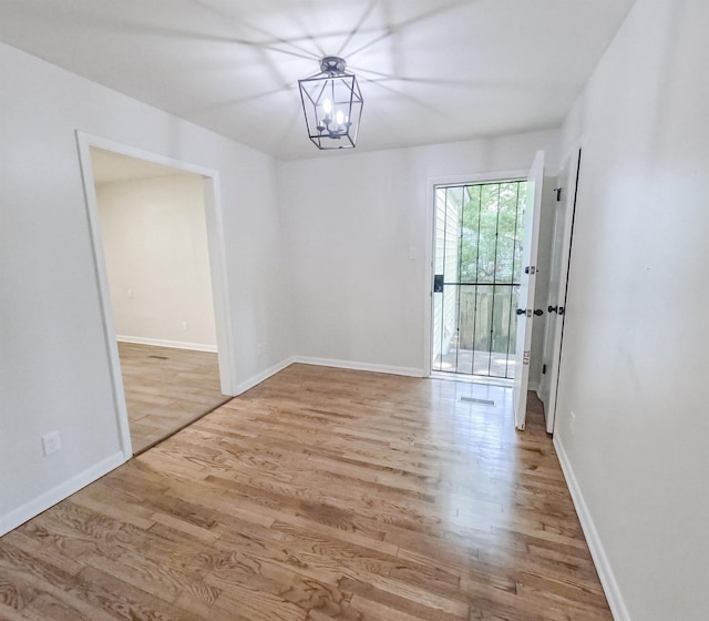 3547 Randolph St, Memphis, TN 38127 - empty room with wood finished floors, baseboards, and a chandelier