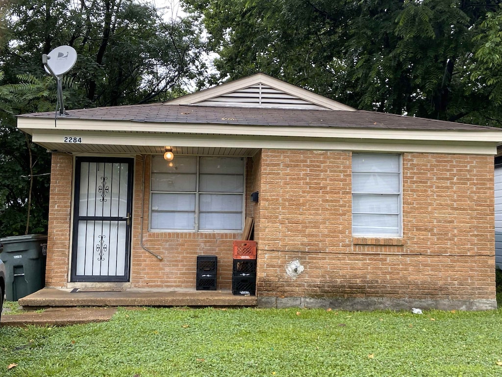 2284 Norman Ave, Memphis, TN 38108 - view of front of home with brick siding, a front lawn, and a shingled roof