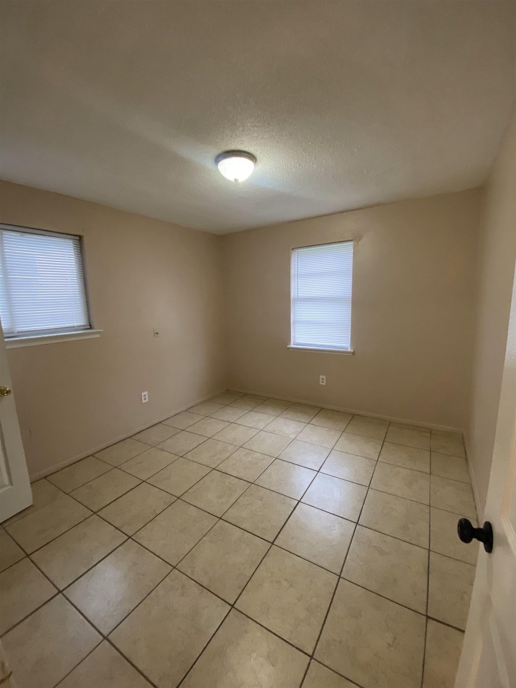2284 Norman Ave, Memphis, TN 38108 - empty room with plenty of natural light, light tile patterned floors, and a textured ceiling