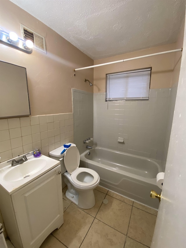 2284 Norman Ave, Memphis, TN 38108 - full bathroom with shower / washtub combination, a textured ceiling, toilet, tile patterned flooring, and tile walls