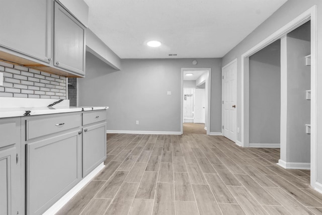 5315 Sleepy Oak Cv, Memphis, TN 38141 - kitchen featuring light countertops, light wood-style flooring, baseboards, and decorative backsplash