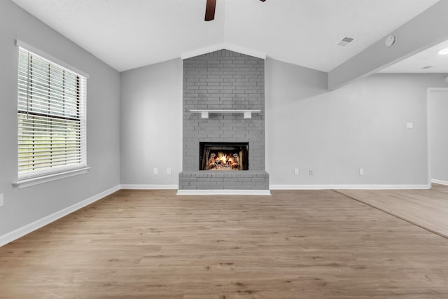 5315 Sleepy Oak Cv, Memphis, TN 38141 - unfurnished living room with a ceiling fan, light wood-type flooring, vaulted ceiling, a fireplace, and healthy amount of natural light