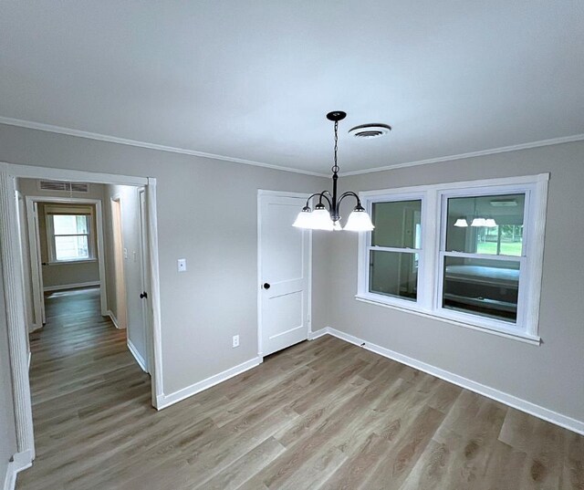 4485 Dunn Rd, Memphis, TN 38117 - unfurnished dining area featuring ornamental molding, light wood-style flooring, a chandelier, and baseboards