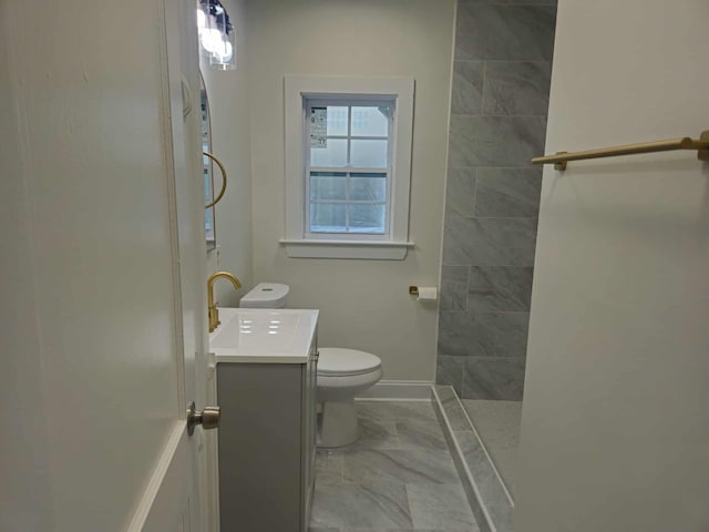 4078 Burrow Ave, Memphis, TN 38128 - bathroom featuring vanity, a tile shower, toilet, marble look tiles, and baseboards