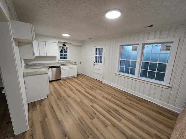 4078 Burrow Ave, Memphis, TN 38128 - kitchen featuring dishwasher, a textured ceiling, light wood finished floors, white cabinets, and light stone counters