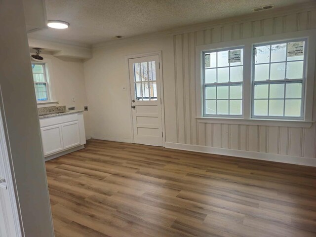 4078 Burrow Ave, Memphis, TN 38128 - kitchen with light wood-style floors, a textured ceiling, white cabinetry, and baseboards