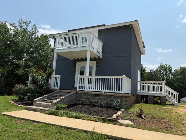 135 Lapa Ln, Clifton, TN 38425 - view of front of house with a balcony, covered porch, and stairway