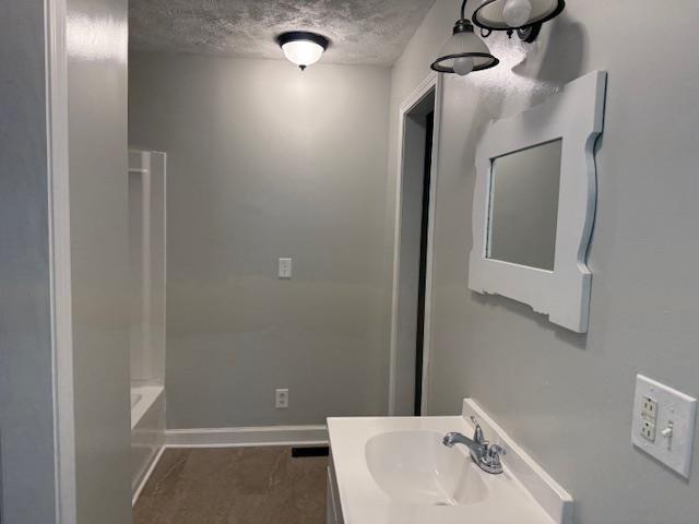 135 Lapa Ln, Clifton, TN 38425 - bathroom featuring vanity, baseboards, and a textured ceiling