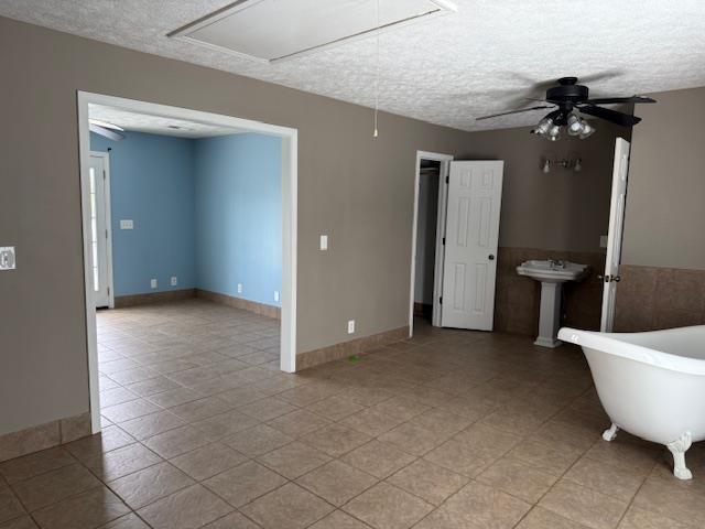 135 Lapa Ln, Clifton, TN 38425 - empty room with attic access, a textured ceiling, ceiling fan, a sink, and light tile patterned floors