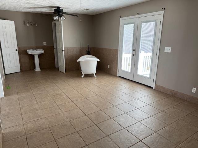 135 Lapa Ln, Clifton, TN 38425 - unfurnished room featuring french doors, tile walls, healthy amount of natural light, a textured ceiling, and light tile patterned floors