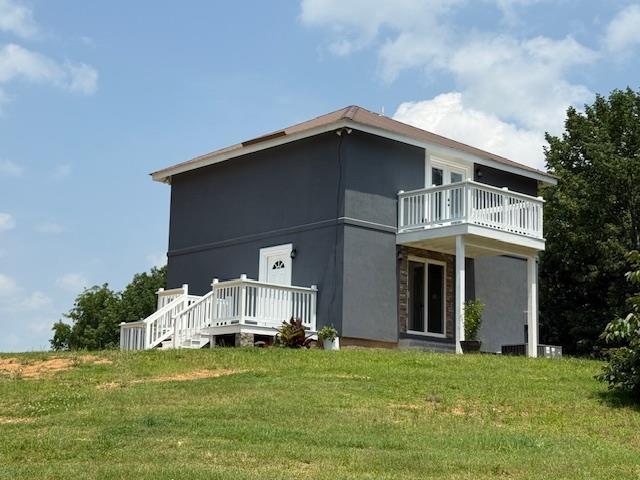 135 Lapa Ln, Clifton, TN 38425 - view of side of property featuring a lawn and stucco siding
