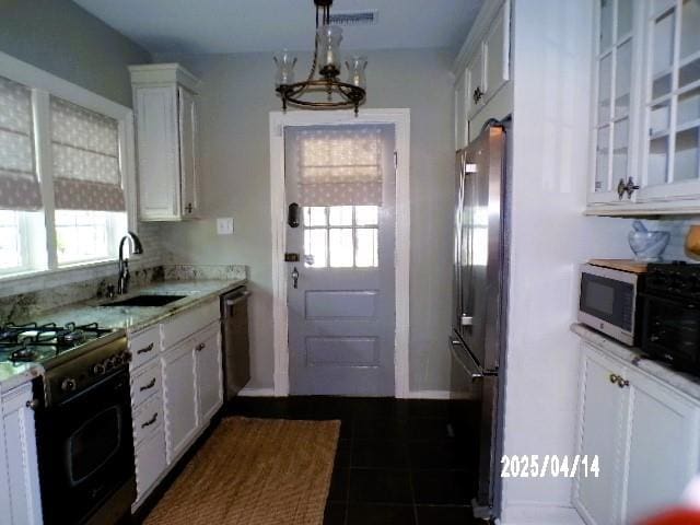 400 S Reese St, Memphis, TN 38111 - kitchen featuring a sink, freestanding refrigerator, gas stove, dishwasher, and white cabinetry
