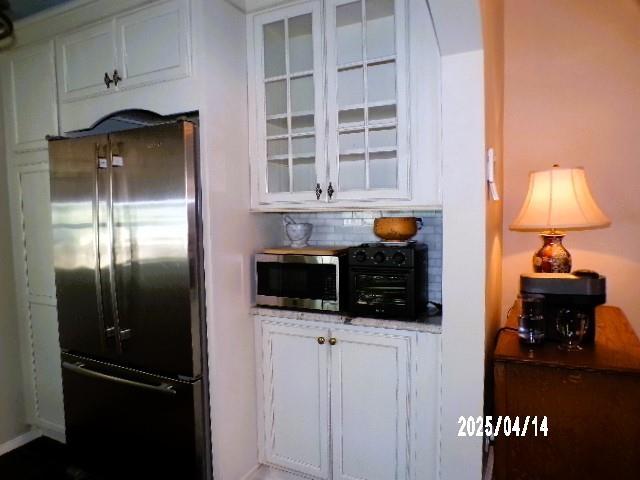 400 S Reese St, Memphis, TN 38111 - kitchen with fridge, white cabinets, glass insert cabinets, and decorative backsplash