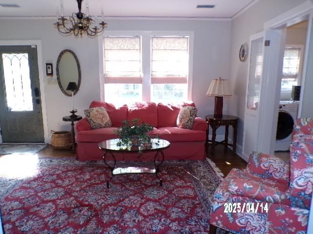 400 S Reese St, Memphis, TN 38111 - living area with washer / clothes dryer, ornamental molding, wood finished floors, and a chandelier