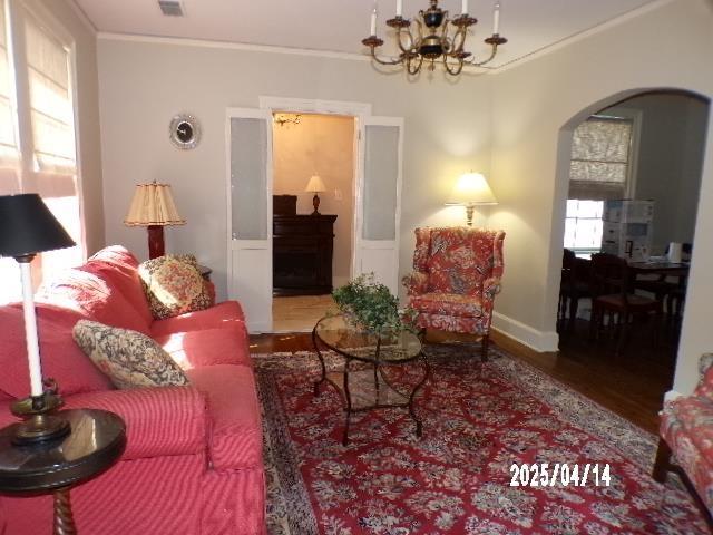 400 S Reese St, Memphis, TN 38111 - living area with arched walkways, wood finished floors, a chandelier, crown molding, and baseboards