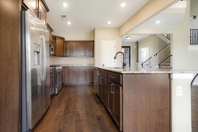 35 Laurel Pointe Cv, Oakland, TN 38060 - kitchen featuring appliances with stainless steel finishes, a sink, dark wood-type flooring, an island with sink, and light stone counters