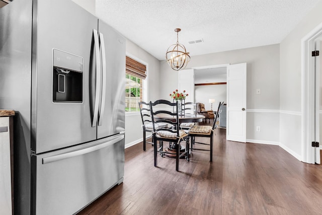 7255 Barnstable Dr, Memphis, TN 38125 - dining area with dark wood-type flooring, a chandelier, a textured ceiling, and baseboards