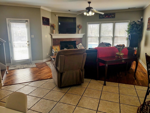 197 Walnut Gardens Dr, Memphis, TN 38018 - living area featuring a ceiling fan, light tile patterned floors, crown molding, baseboards, and a brick fireplace
