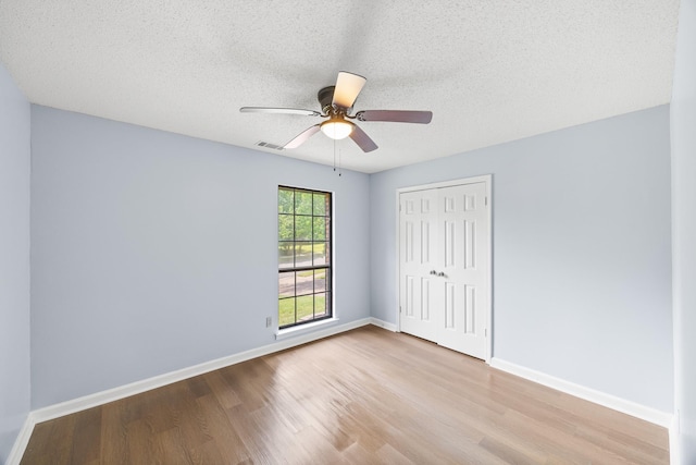 5424 Peyton Randolph St, Bartlett, TN 38134 - unfurnished bedroom with wood finished floors, a closet, baseboards, a textured ceiling, and a ceiling fan