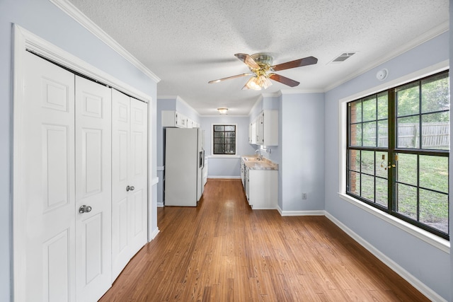 5424 Peyton Randolph St, Bartlett, TN 38134 - kitchen featuring refrigerator with ice dispenser, baseboards, plenty of natural light, white cabinetry, and a textured ceiling