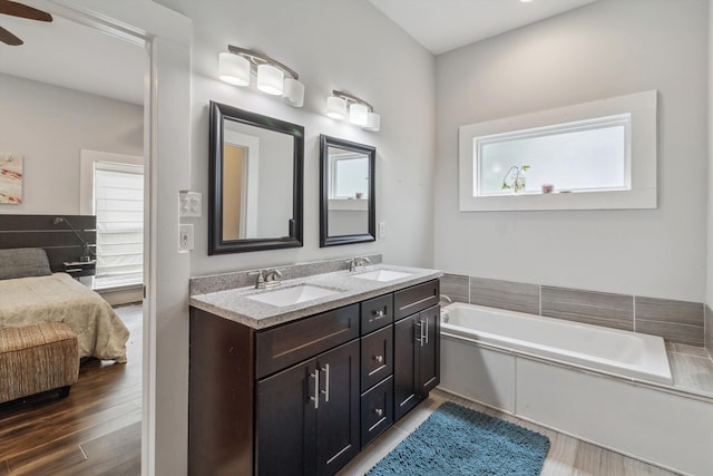 2106 Higbee Ave, Memphis, TN 38104 - full bathroom featuring double vanity, a garden tub, ceiling fan, ensuite bath, and wood finished floors
