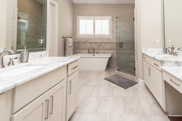 12432 Zapata Cv, Collierville, TN 38017 - bathroom featuring two vanities, a stall shower, a freestanding bath, and tile patterned flooring