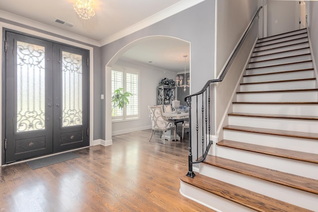 12432 Zapata Cv, Collierville, TN 38017 - entrance foyer featuring arched walkways, french doors, a chandelier, stairs, and crown molding