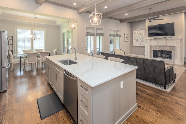 12432 Zapata Cv, Collierville, TN 38017 - kitchen featuring appliances with stainless steel finishes, a sink, an island with sink, open floor plan, and a tile fireplace