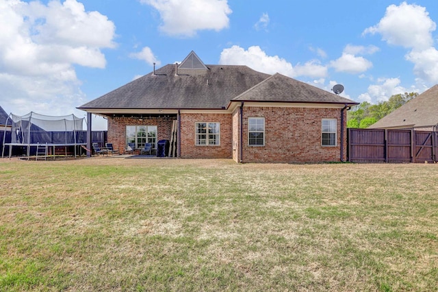 6486 Anglia Valley Dr, Arlington, TN 38002 - back of house with a trampoline, brick siding, a shingled roof, and a patio