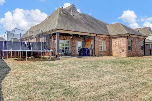 6486 Anglia Valley Dr, Arlington, TN 38002 - back of house with a trampoline, brick siding, and roof with shingles