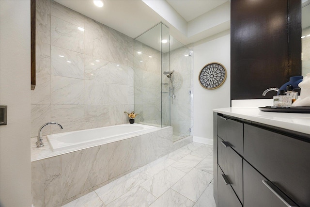 717 Riverside Dr Unit 1104, Memphis, TN 38103 - bathroom featuring marble look tile flooring, a garden tub, a tile shower, vanity, and baseboards