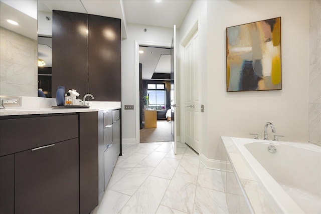 717 Riverside Dr Unit 1104, Memphis, TN 38103 - full bathroom featuring vanity, a bath, baseboards, marble look tiles, and ensuite bathroom