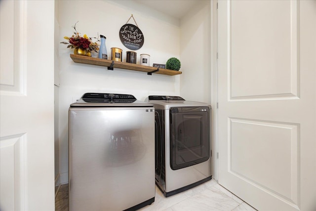 717 Riverside Dr Unit 1104, Memphis, TN 38103 - laundry area featuring washing machine and clothes dryer and light marble finish floors