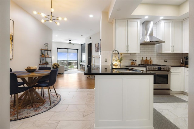 717 Riverside Dr Unit 1104, Memphis, TN 38103 - kitchen featuring wall chimney exhaust hood, stainless steel gas stove, dark countertops, a sink, and light marble finish flooring