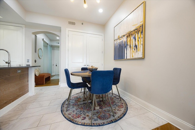 717 Riverside Dr Unit 1104, Memphis, TN 38103 - dining area featuring arched walkways, light marble finish flooring, and baseboards