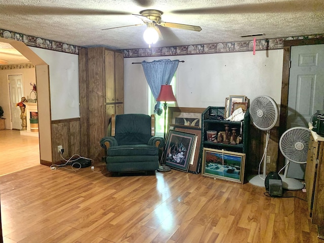 24335 US Highway 64, Hornsby, TN 38044 - living area with wood finished floors, a ceiling fan, a textured ceiling, and wood walls