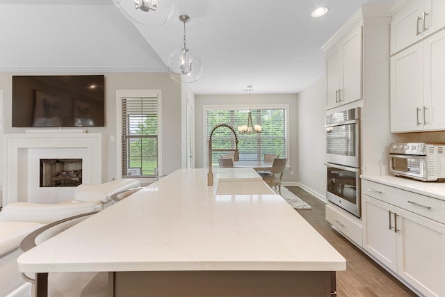 9709 Woodland Brook Ln S, Cordova, TN 38018 - kitchen featuring stainless steel double oven, a chandelier, pendant lighting, a kitchen island, and white cabinetry