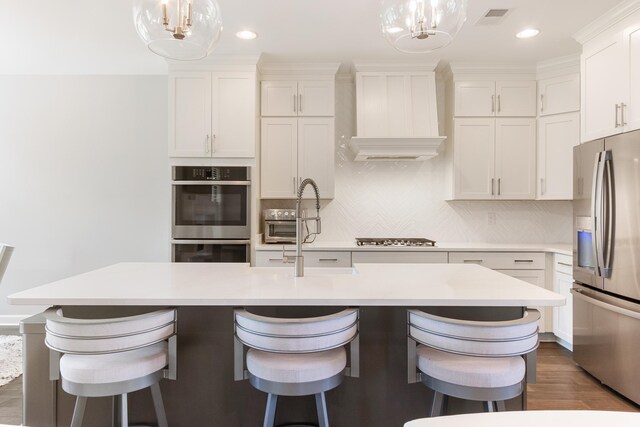 9709 Woodland Brook Ln S, Cordova, TN 38018 - kitchen featuring appliances with stainless steel finishes, a chandelier, white cabinets, premium range hood, and recessed lighting