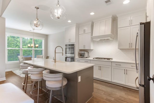 9709 Woodland Brook Ln S, Cordova, TN 38018 - kitchen with appliances with stainless steel finishes, custom range hood, a chandelier, a sink, and an island with sink
