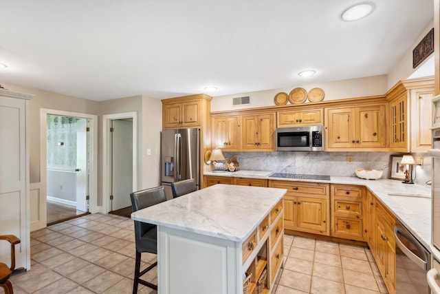 8741 Montavesta Dr, Germantown, TN 38139 - kitchen featuring appliances with stainless steel finishes, backsplash, light stone countertops, a kitchen island, and a kitchen bar