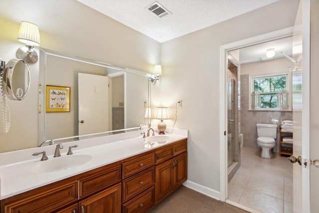 8741 Montavesta Dr, Germantown, TN 38139 - bathroom featuring toilet, double vanity, a stall shower, and tile patterned flooring