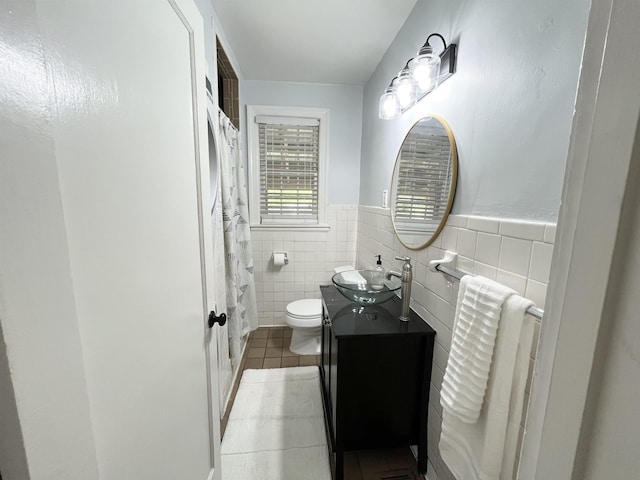 3529 Johnwood Dr, Memphis, TN 38122 - bathroom featuring toilet, tile patterned floors, vanity, tile walls, and wainscoting