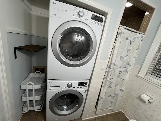 3529 Johnwood Dr, Memphis, TN 38122 - washroom with stacked washer / drying machine, tile walls, tile patterned floors, and wainscoting