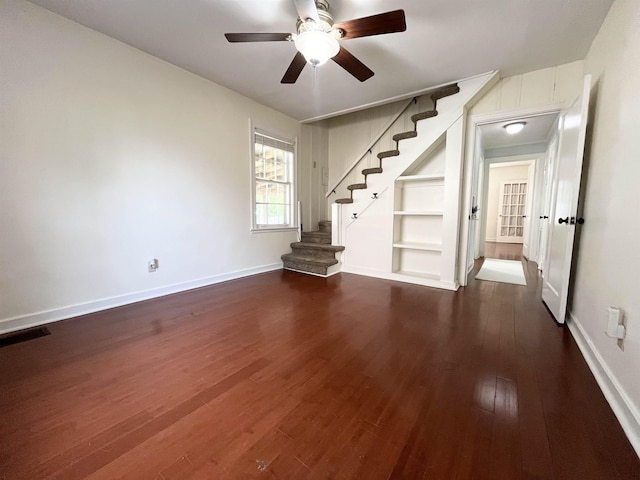 3529 Johnwood Dr, Memphis, TN 38122 - unfurnished living room featuring a ceiling fan, stairs, dark wood-type flooring, built in features, and baseboards