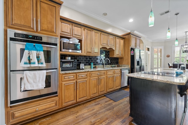1073 Woodland Glen Dr, Cordova, TN 38018 - kitchen featuring stainless steel appliances, dark wood finished floors, brown cabinetry, decorative backsplash, and a center island