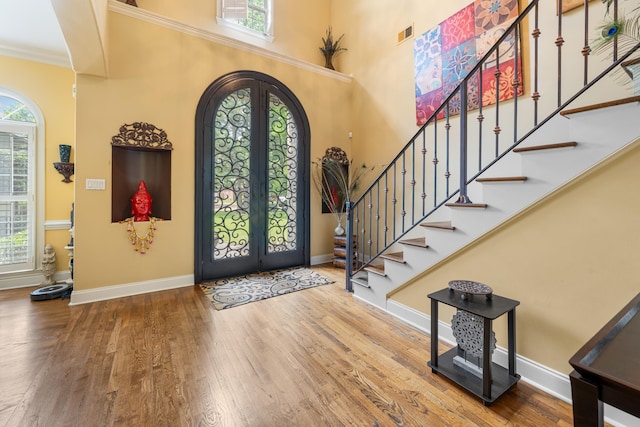 1073 Woodland Glen Dr, Cordova, TN 38018 - foyer featuring arched walkways, french doors, stairs, wood finished floors, and ornamental molding